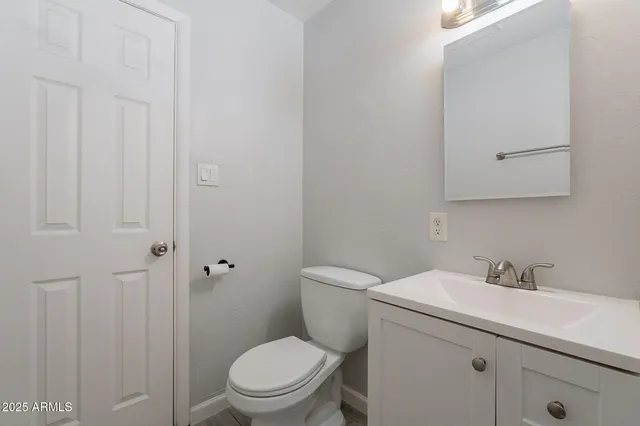 a bathroom with a toilet sink vanity and mirror