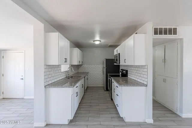 a kitchen with stainless steel appliances granite countertop a sink stove and refrigerator