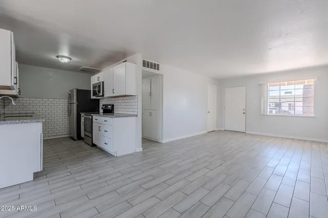 a view of kitchen with wooden floor and electronic appliances