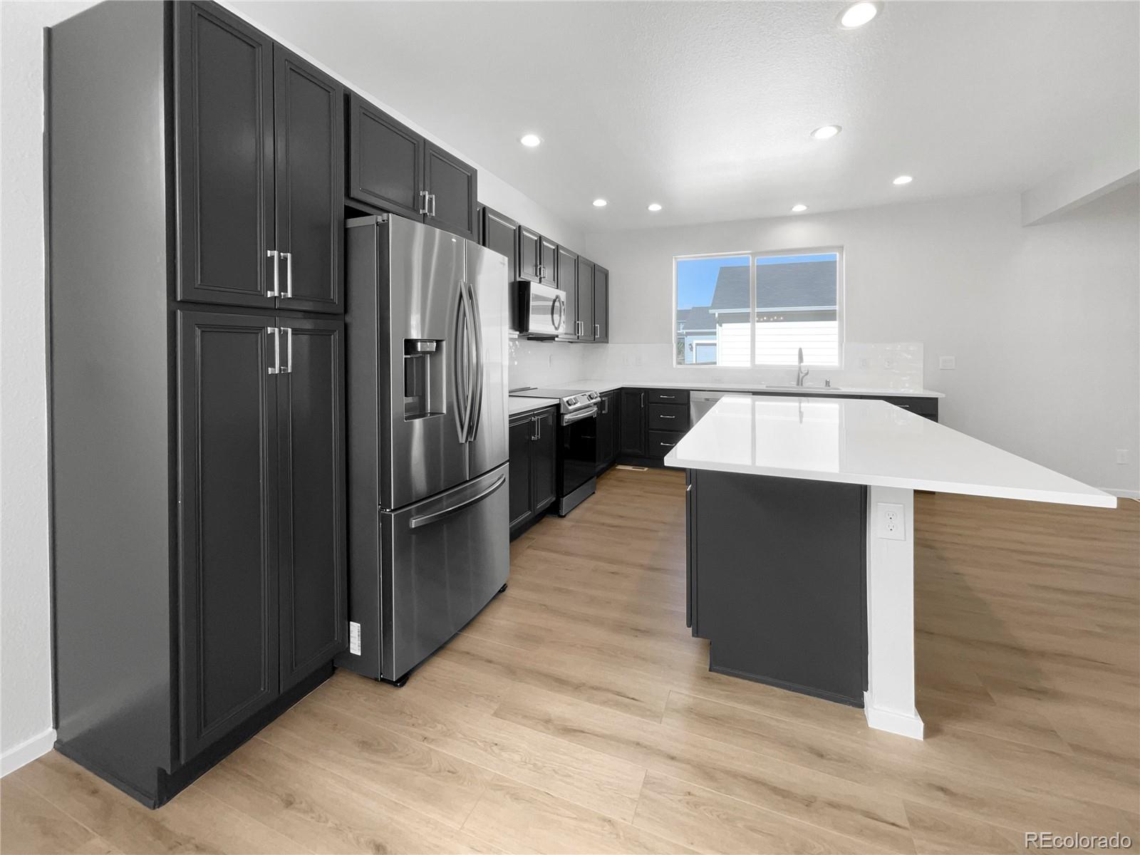 12825 Eagle River Road Firestone, CO 80504 - Photo 12 of 32 a kitchen with stainless steel appliances granite countertop a refrigerator and a sink