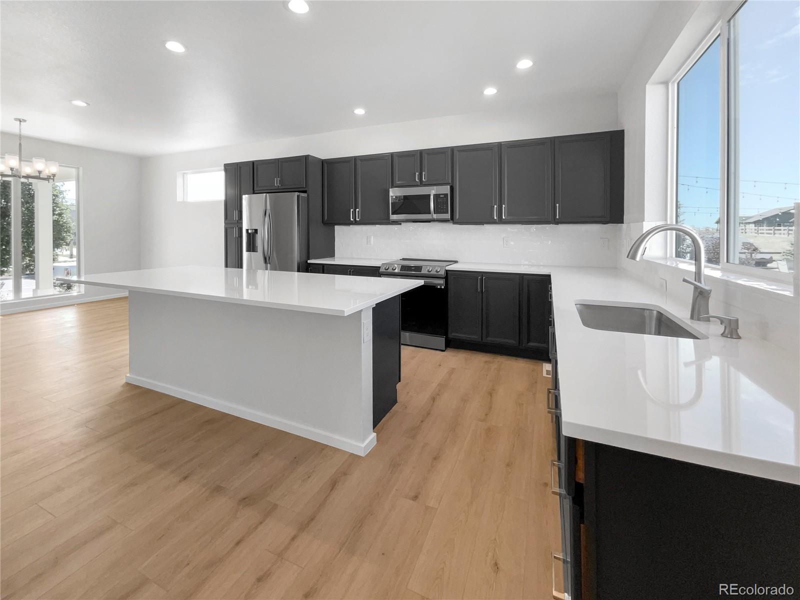 12825 Eagle River Road Firestone, CO 80504 - Photo 13 of 32 a large kitchen with stainless steel appliances a sink dishwasher a stove and a wooden cabinets