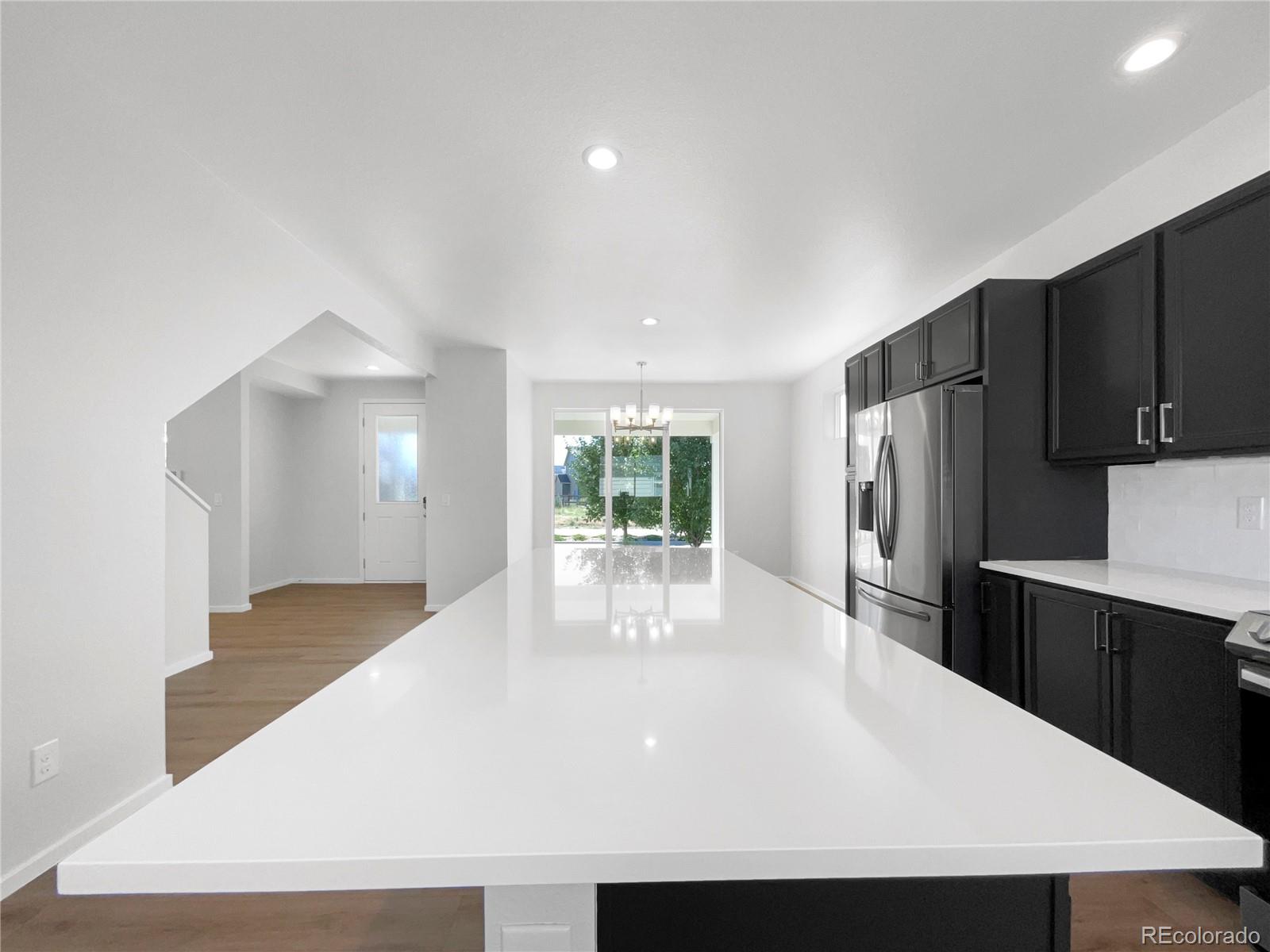 12825 Eagle River Road Firestone, CO 80504 - Photo 14 of 32 a kitchen with stainless steel appliances a refrigerator a sink dishwasher with a dining table and chairs