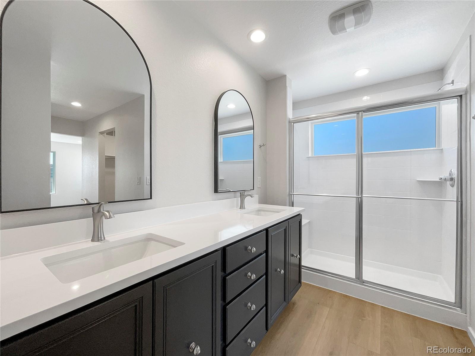 12825 Eagle River Road Firestone, CO 80504 - Photo 23 of 32 a bathroom with a double vanity sink and mirror