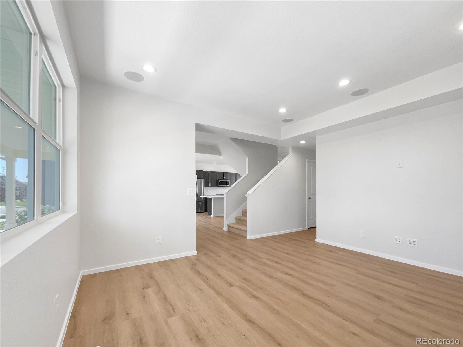 12825 Eagle River Road Firestone, CO 80504 - Photo 3 of 32 a view of empty room with wooden floor and fan