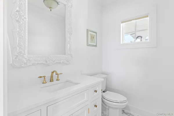 a bathroom with a sink a toilet and a mirror