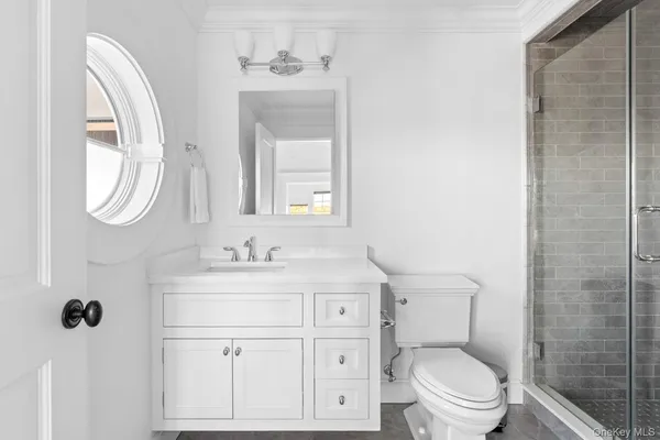 a bathroom with a granite countertop toilet sink and mirror