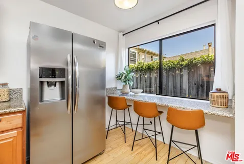 a kitchen with stainless steel appliances granite countertop a refrigerator and a table