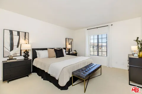 a bedroom with a bed window and a flat screen tv