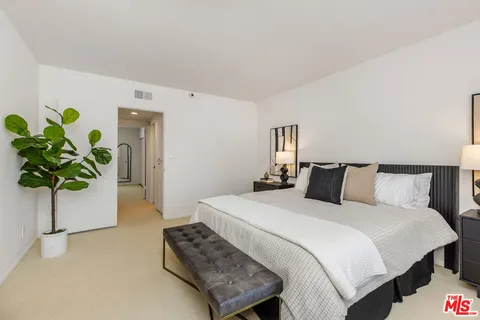 a bedroom with a bed potted plant and a potted plant
