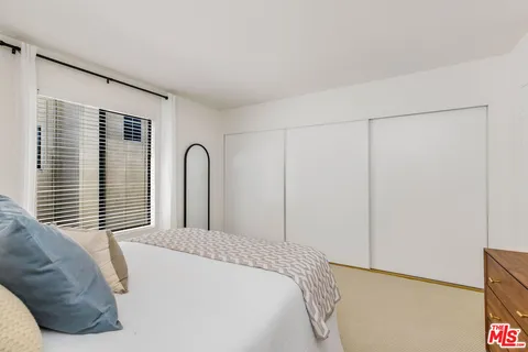 a bedroom with a bed and a large window