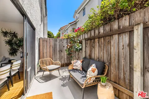 an outdoor sitting area with furniture and wooden fence