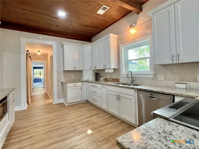 a kitchen with a sink window and cabinets