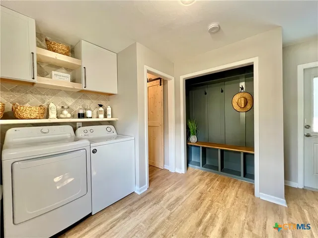 a living room with a black white checkered floor with a gaming machine and dining chairs