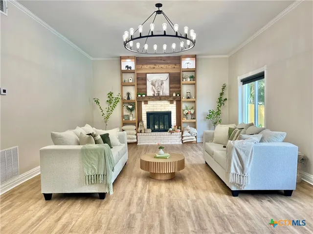 a living room with furniture a fireplace and a large window