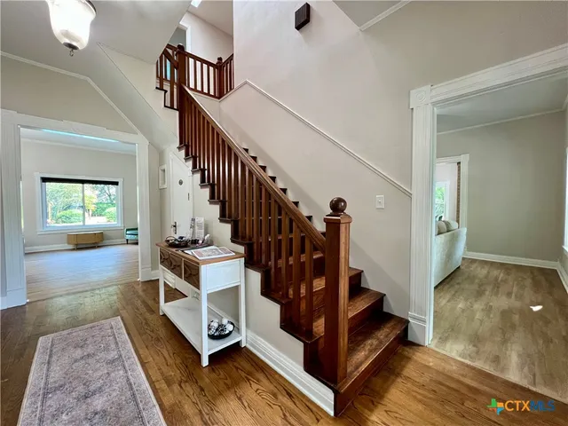 a view of an entryway with wooden floor and stairs