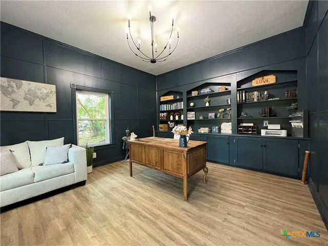 a living room with furniture a chandelier and a dining table