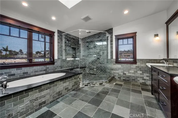 a bathroom with a granite countertop sink a mirror and a bathtub