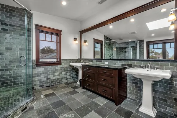 a bathroom with a sink a large mirror and a shower