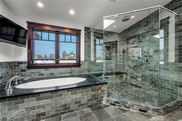 a bathroom with a granite countertop sink a mirror and shower