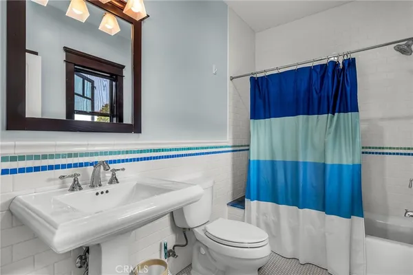 a bathroom with a sink a toilet and shower curtain