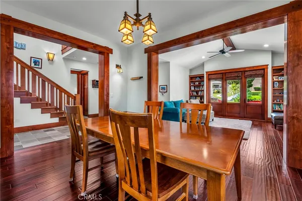 a view of a dining room with furniture a chandelier and wooden floor