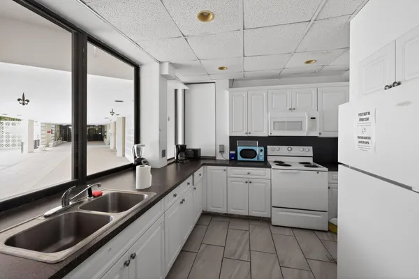 a kitchen filled with white cabinets and white appliances