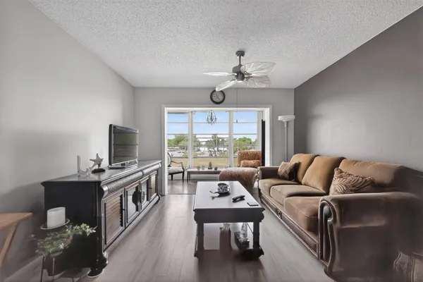 a living room with furniture flat screen tv and a large window