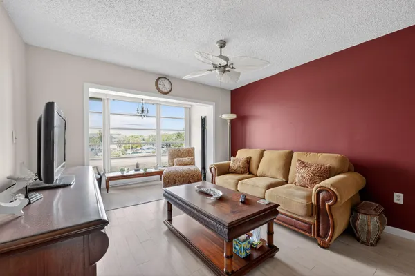 a living room with furniture a flat screen tv and a large window