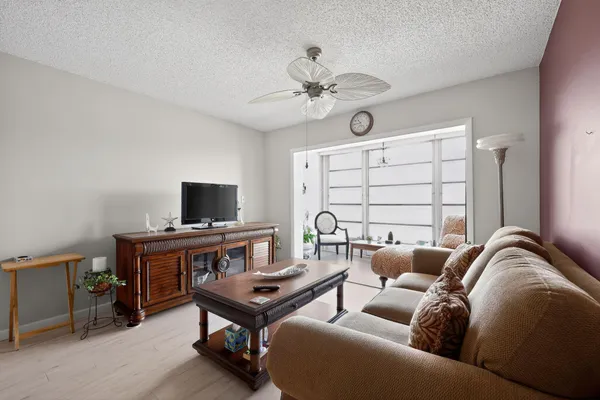a living room with furniture a flat screen tv and a window