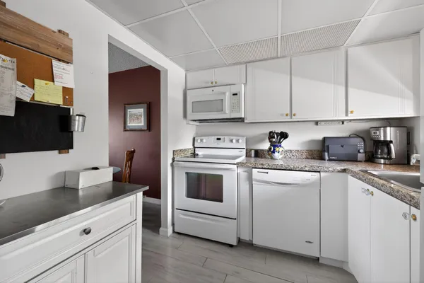 a kitchen with white cabinets and white appliances
