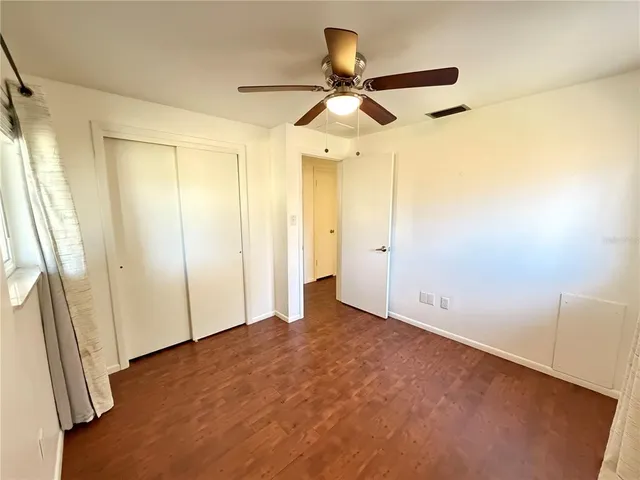 an empty room with a mirror and a ceiling fan