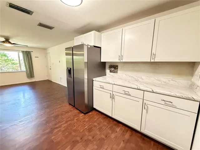 a kitchen with a refrigerator sink and cabinets