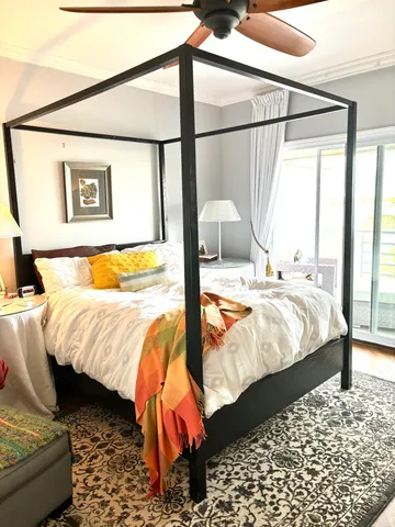 a bed sitting in a bedroom next to a window