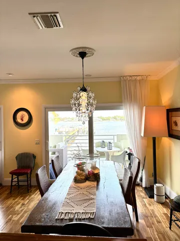 a view of a dining room with furniture a chandelier and wooden floor