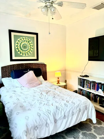 a bedroom with a bed and a book shelf