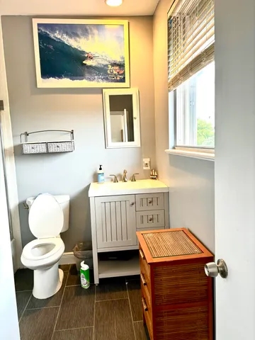 a bathroom with a toilet a sink and a window