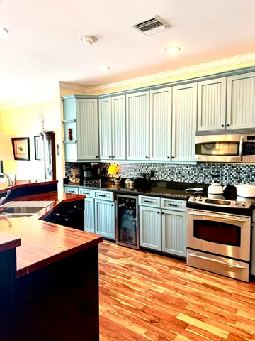 a kitchen with granite countertop a sink cabinets and stainless steel appliances