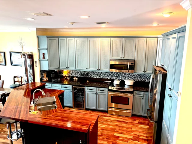 a kitchen with stainless steel appliances granite countertop a stove top oven a sink a counter space and cabinets