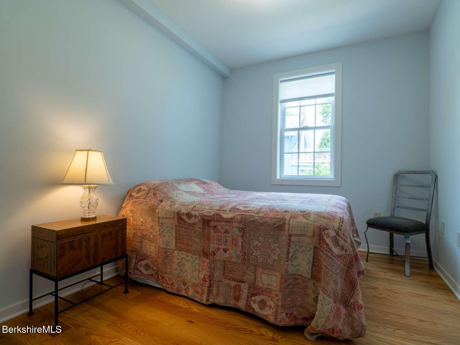 160 High Street Lee, MA 01238 - Photo 8 of 41 a bedroom with a bed a lamp and wooden floor