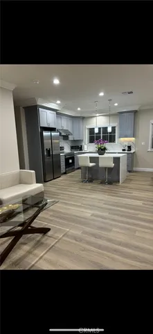 a view of a kitchen with kitchen island a sink wooden floor and counter top