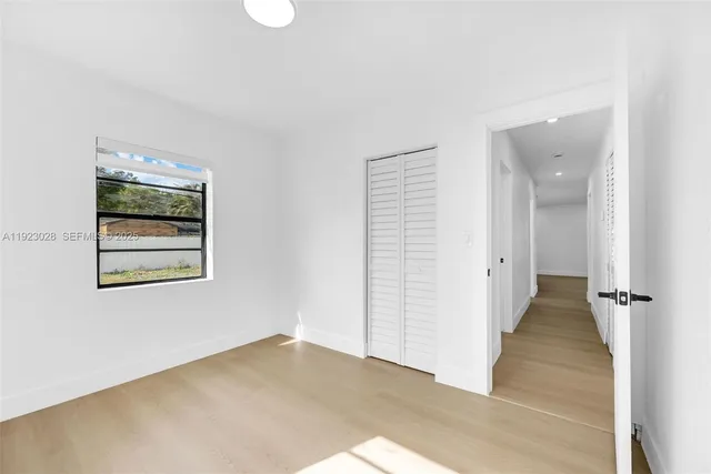 an empty room with windows and closet