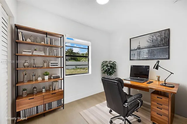 a view of a workspace with furniture and a window