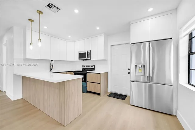 a kitchen with stainless steel appliances a refrigerator sink and microwave