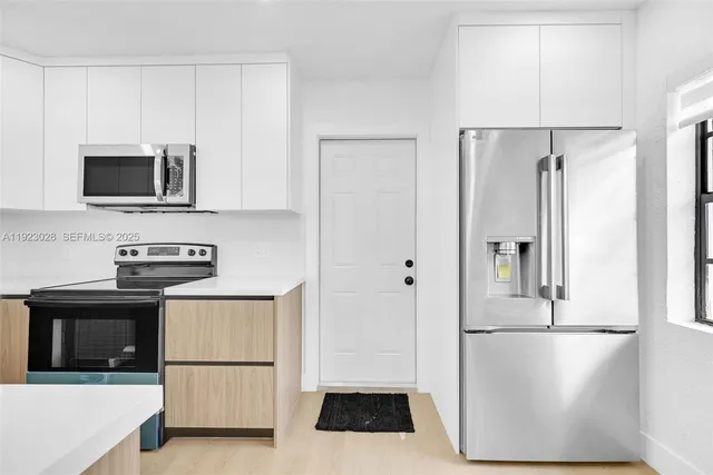 a kitchen with stainless steel appliances a refrigerator stove and microwave