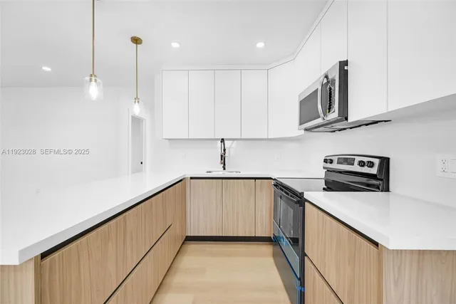 a kitchen with stainless steel appliances granite countertop a sink a stove and a refrigerator