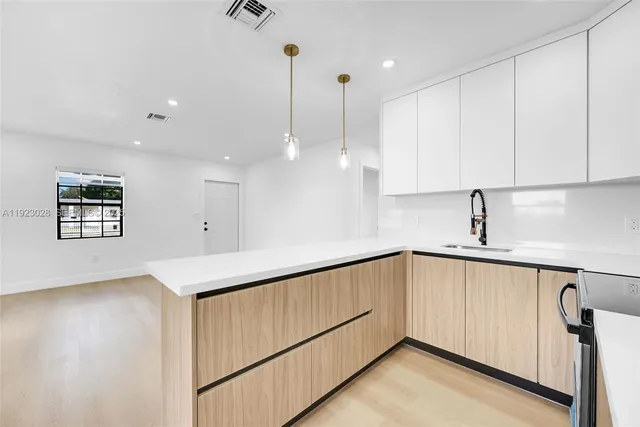 a kitchen with stainless steel appliances granite countertop a sink a stove and a wooden floors