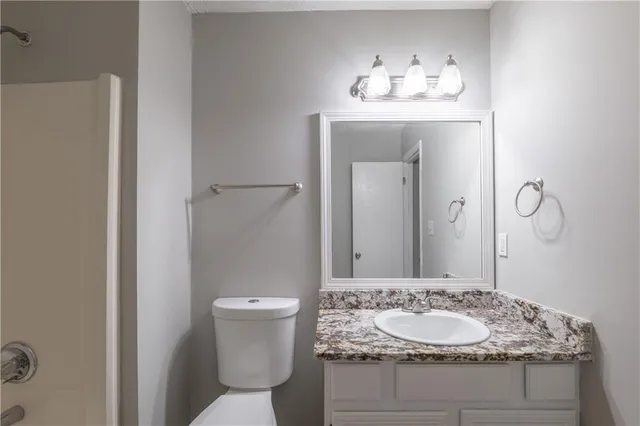 an empty room with a chandelier fan and windows
