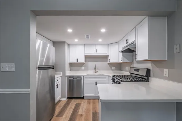a view of a kitchen with a sink and refrigerator