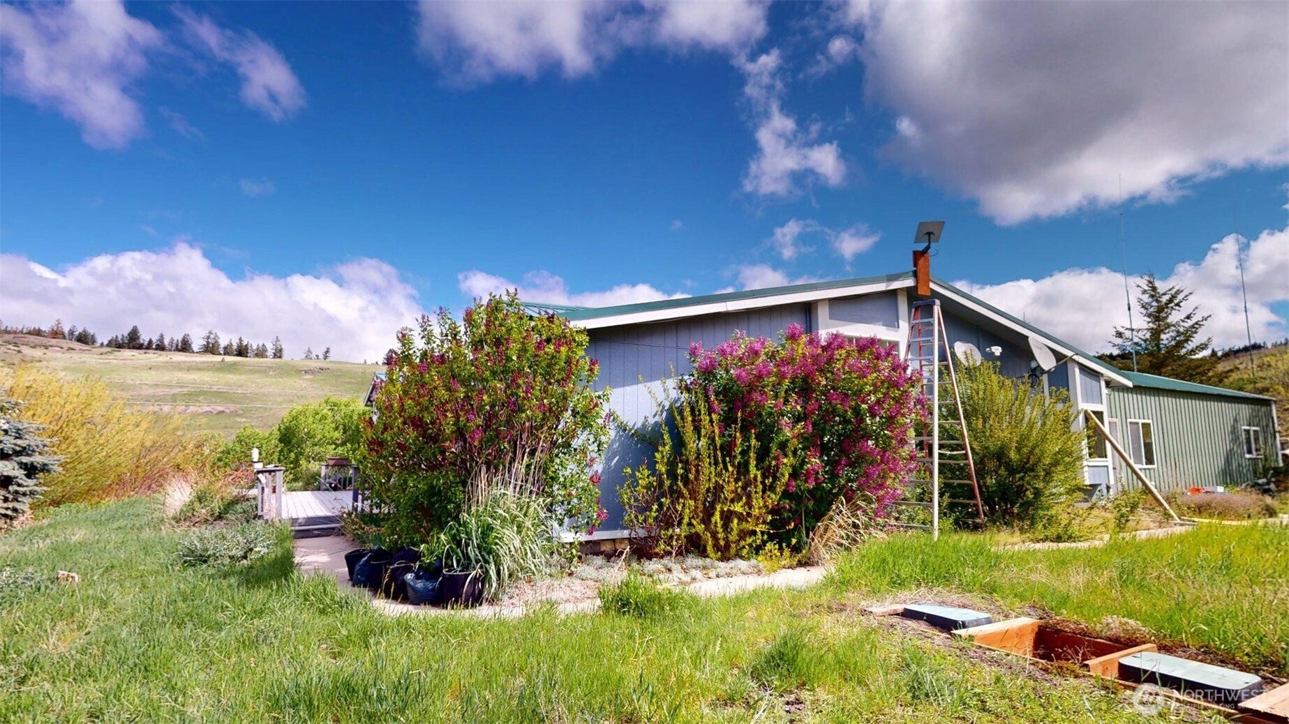142 Fletcher Road Oroville, WA 98844 - Photo 23 of 26 a view of a backyard with plants and a patio