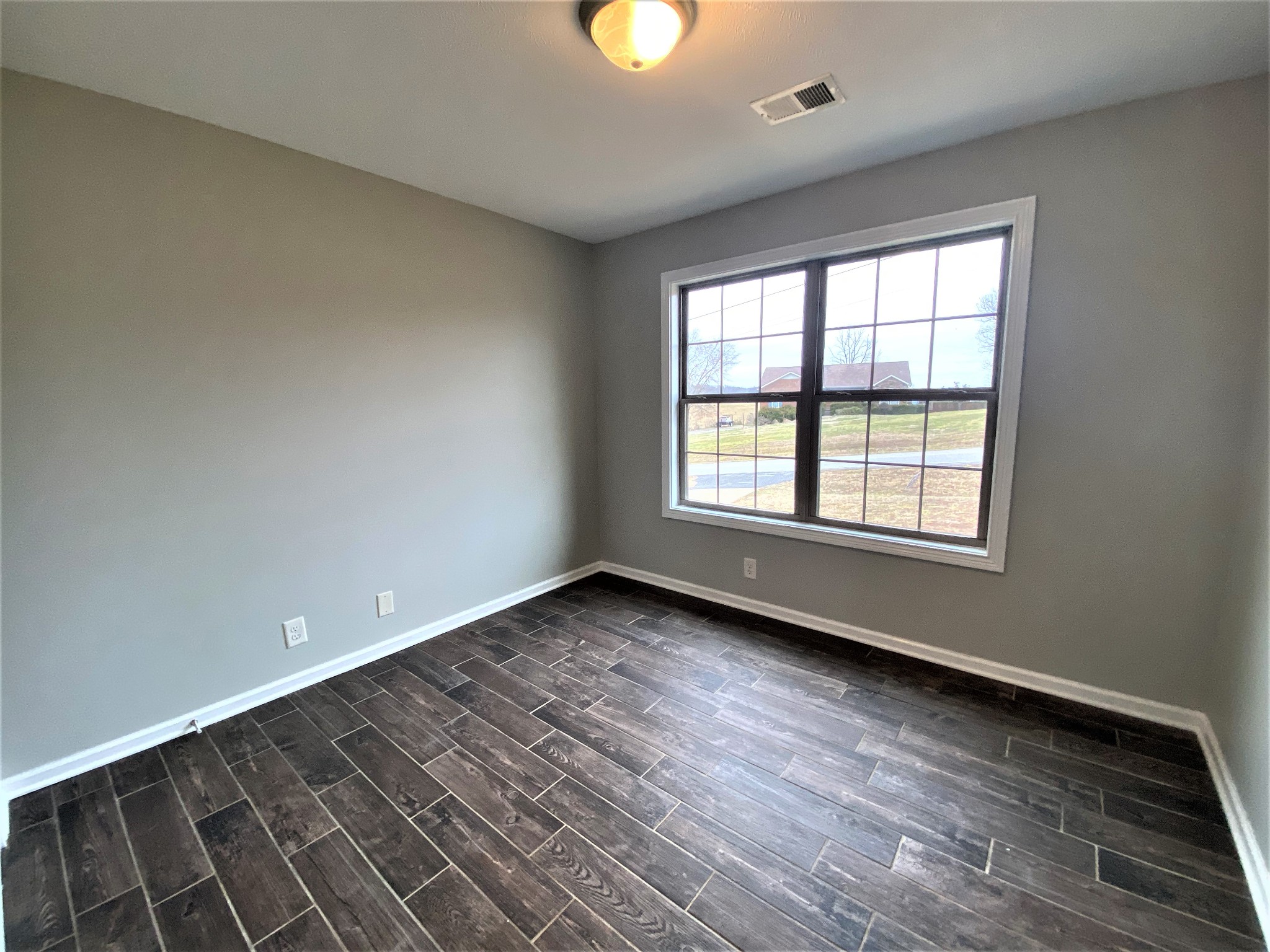 4200 Station Road Cunningham, TN 37052 - Photo 19 of 37 a view of an empty room with wooden floor and window